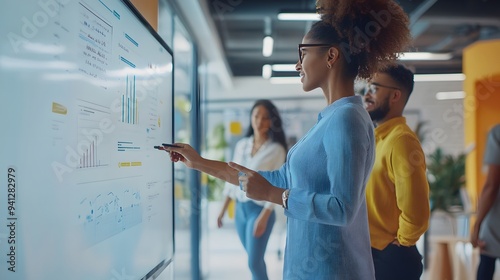 6. A group of office workers collaborating on a digital whiteboard in a bright, open workspace photo