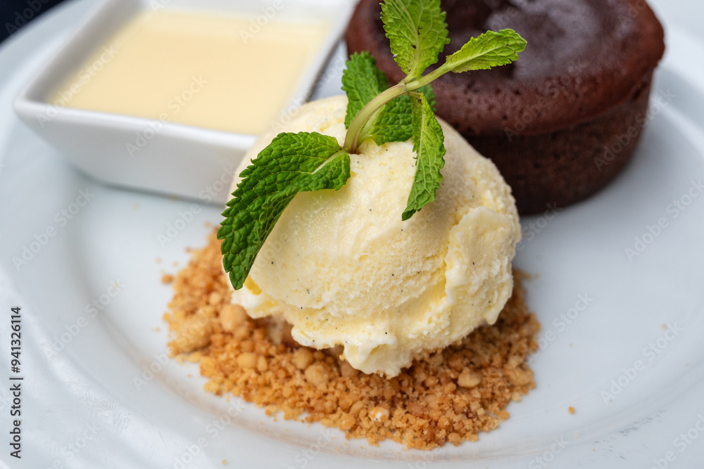 vanilla ice cream and sauce served as an addition to chocolate fudge brownie cake vanilla ice cream and sauce served as an addition to chocolate fudge brownie cake
