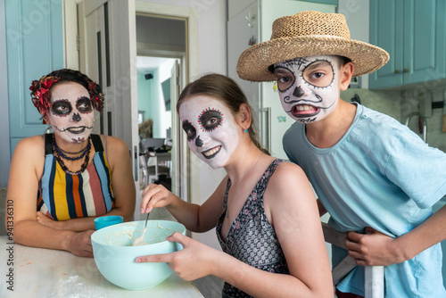 mother and children prepare bread of the dead for the holiday, day of the dead in mexico, halloween, family having fun and baking pies, dough, flour, buns, hands,