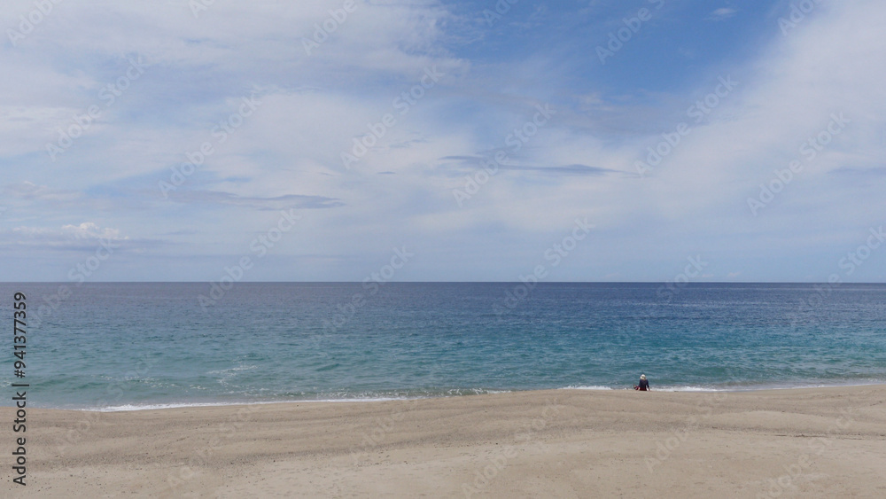Plage du Limone, Corsica. Idyllic deserted beach , Plage du Limone in Corsica. Blue sky appearing through an overcast sky with a calm mediterranean sea.