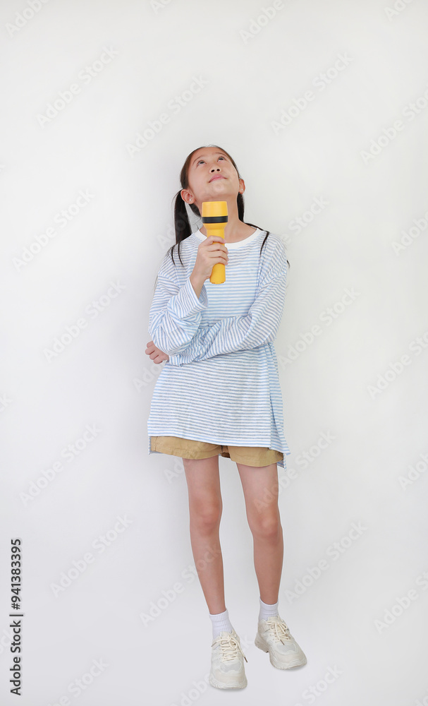 Asian girl child hold and shining a flashlight up empty space over white background. Kid and discovery concept. Full body photo. Asian girl child hold and shining a flashlight up empty space over white background. Kid and discovery concept. Full body photo.