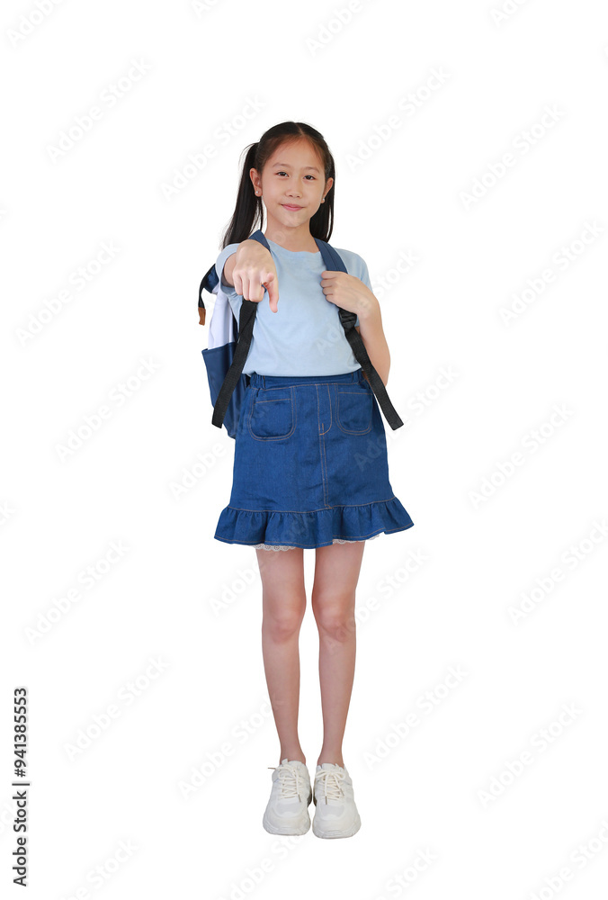 Smiling Asian girl child with backpack bag pointing index finger straight at you posture isolated on white background. Image full length. Smiling Asian girl child with backpack bag pointing index finger straight at you posture isolated on white background. Image full length.