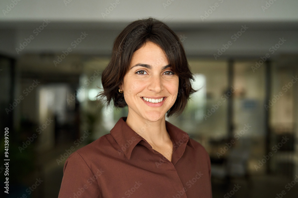 © insta_photos - Headshot close up face portrait of young happy smiling Hispanic businesswoman, female company worker or corporate manager, confident business woman entrepreneur looking at camera at work in office. © insta_photos - Headshot close up face portrait of young happy smiling Hispanic businesswoman, female company worker or corporate manager, confident business woman entrepreneur looking at camera at work in office.