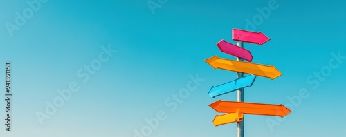 Colorful directional signs against a clear blue sky, symbolizing travel, choices, and possibilities.