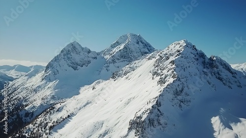 Breathtaking Aerial View of Snowy Mountain Range Against Bright Blue Sky