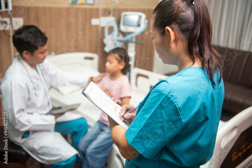 A team of doctors and nurses are working to treat a female patient in the patient's room.