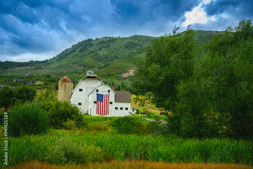 Classic Landmark Farmhouse with dramatic stormy clouds rising behind the Wasatch Mountain Range in the Historic Park City, Utah, USA