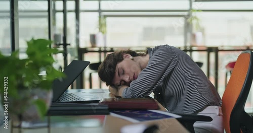 Young adult gen z lazy woman lady sitting do over time work feel lack sleep tired fall asleep take nap on table job office place bored female girl staff hold tea mug wake up give hot coffee cup day