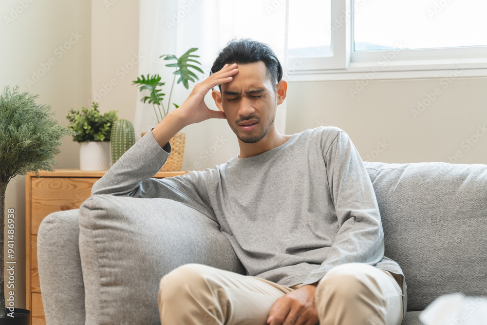 Guy have headache and dizzy sitting on sofa at home Guy have headache and dizzy sitting on sofa at home