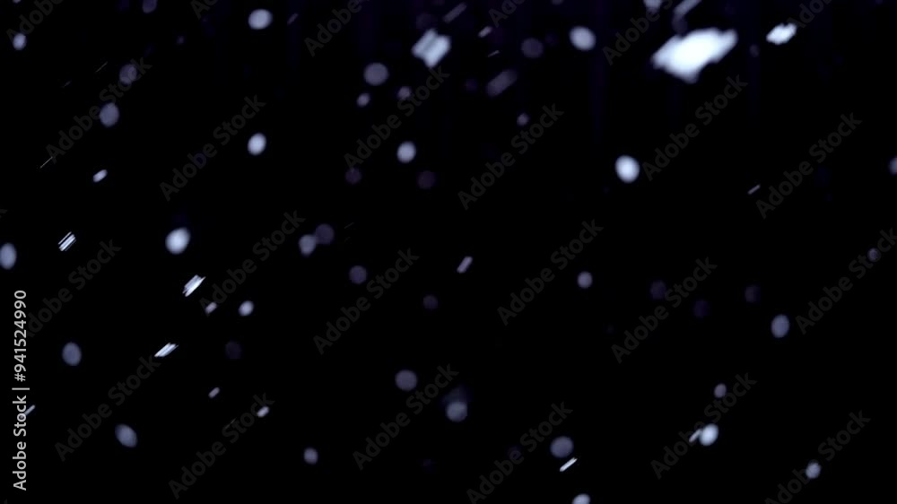 Falling snow on black background. Real Snow falling on dark outside. Small snowflakes over night. Christmas. Defocused Particles. Slowly white bokeh. Heavy snowfall. Winter fairy tale atmosphere.