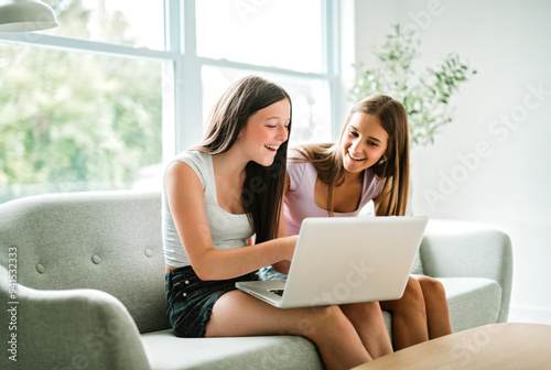 Two teen using laptop in the living room. Friends, friendship, time together