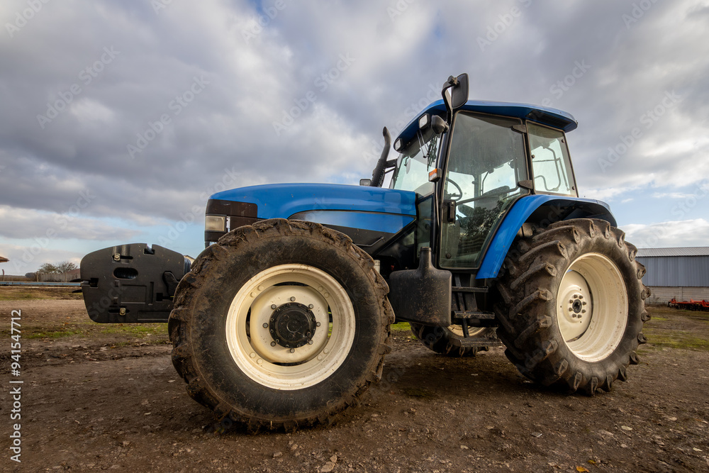 Big blue modern tractor in farm Big blue modern tractor in farm