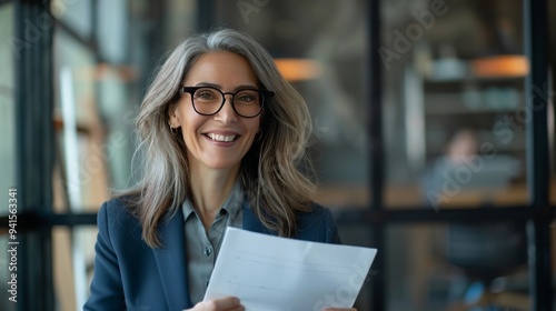 Fototapeta Naklejka Na Ścianę i Meble -  Smiling mature business woman hr holding cv document at job interview. Happy mid aged professional banking manager or lawyer consulting client sitting at workplace in corporate office meeting.