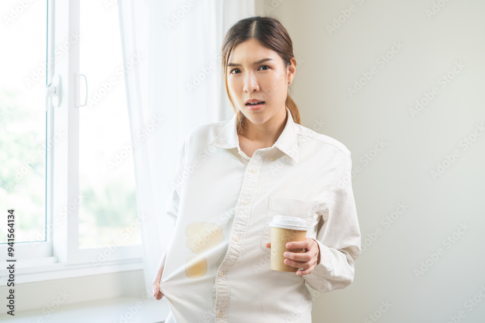 Cloth stain, disappointment asian young woman clumsy with hot coffee, tea stains on shirt, hand show making spill drop on white t-shirt, spot dirty or smudge on clothes at home, isolated on background Cloth stain, disappointment asian young woman clumsy with hot coffee, tea stains on shirt, hand show making spill drop on white t-shirt, spot dirty or smudge on clothes at home, isolated on background