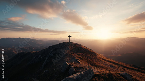 A cross is on top of a mountain, with the sun setting behind it