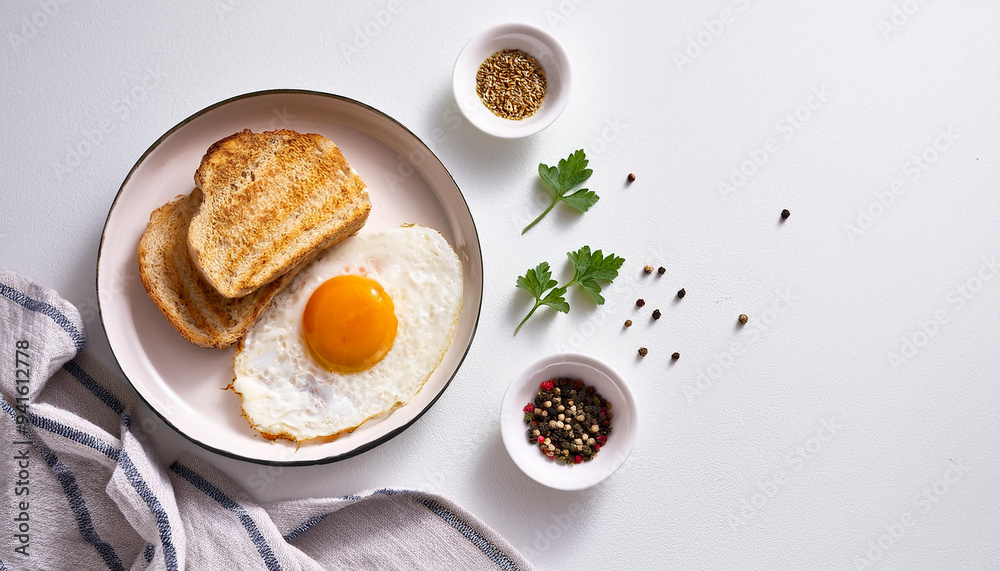 Tasty fried egg with bread and spices served for breakfast. Delicious food. Flat lay. Classic style. Tasty fried egg with bread and spices served for breakfast. Delicious food. Flat lay. Classic style.