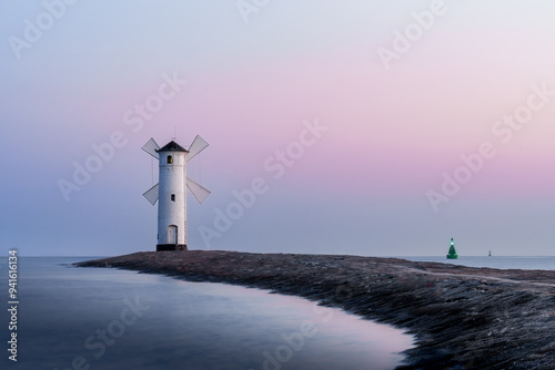 Mühlenbake - Stawa Młyny, a windmill-shaped lighthouse in Świnoujście, Poland, captured at sunset with serene pastel skies over calm waters