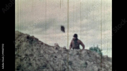 Old archival film, treasure hunter searching for treasure. History documentary gold hunting. Man digging ground with shovel in desert landscape. Vintage adventure archive. Retro discover hidden money