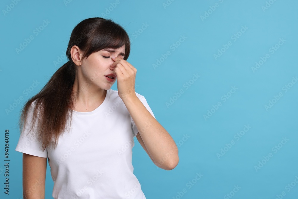 Woman suffering from sinusitis on light blue background. Space for text Woman suffering from sinusitis on light blue background. Space for text