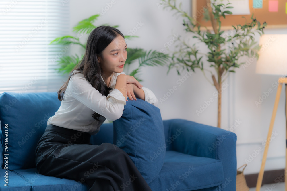 Happy Asian women sitting on the sofa working at home by used laptop and smartphone Happy Asian women sitting on the sofa working at home by used laptop and smartphone