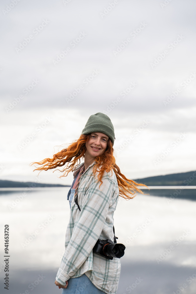 Young woman enjoying lakeside camping with camera Young woman enjoying lakeside camping with camera