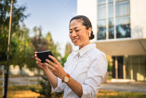 japanese woman stand in front buildings and have video call