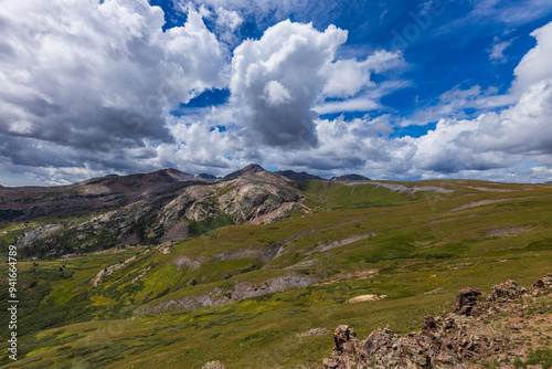 Mountain peaks with tundra meadow and big clouds