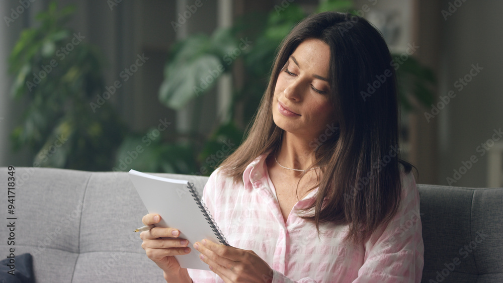 Young woman relaxing on comfortable sofa reading a Young woman relaxing on comfortable sofa reading a