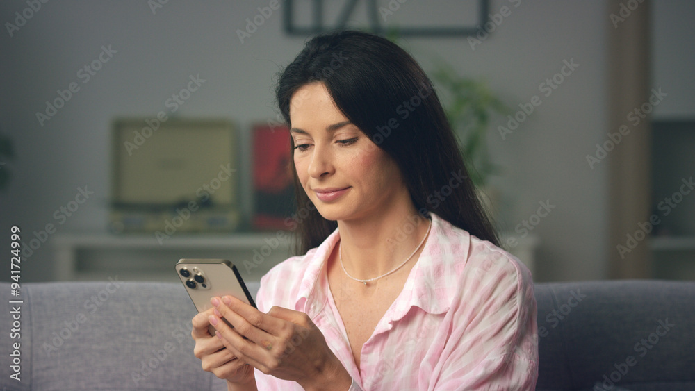 Young woman using smartphone and relaxing on sofa Young woman using smartphone and relaxing on sofa