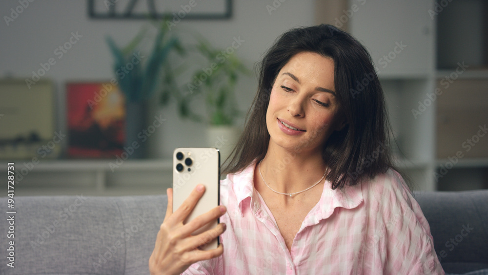 Beautiful woman using smartphone at home on sofa Beautiful woman using smartphone at home on sofa