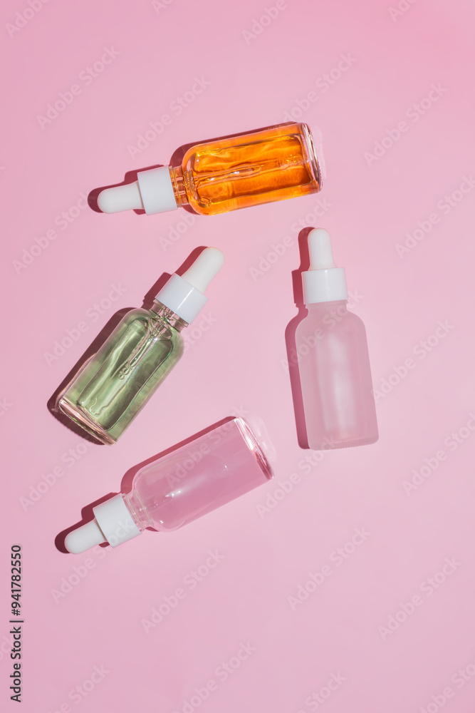 Serums in Dropper Bottles on a Pink Backdrop