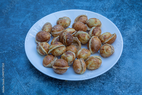 Obraz na płótnie A bowl of delicious walnut-shaped cookies made with boiled condensed milk in a white plate, with a walnut-like appearance made in a cast mold. w salonie