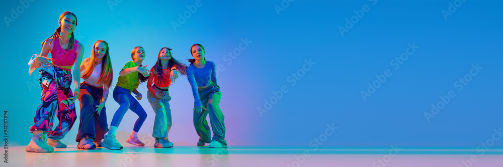 Obraz premium Dancers posing, showing their individuality throw moves in neon light against gradient background with negative space to insert text. Concept of sport and hobby, childhood, friendship, motion.