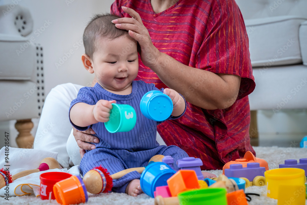 © SKW - A woman and a baby are playing with toys on a carpet. © SKW - A woman and a baby are playing with toys on a carpet.