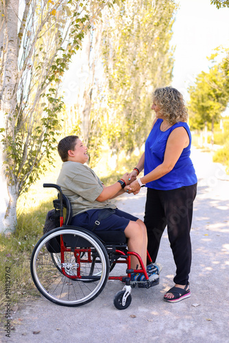 Boy with cerebral palsy interacting with woman outdoors