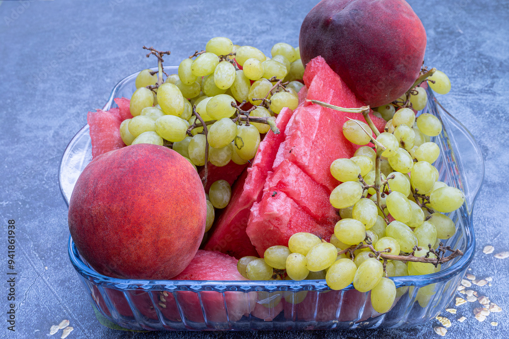 Fruit plate with watermelon, grapes and peach in a glass plate