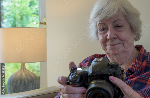 Fotografie Learning a new skill, a senior lady holds a digital camera