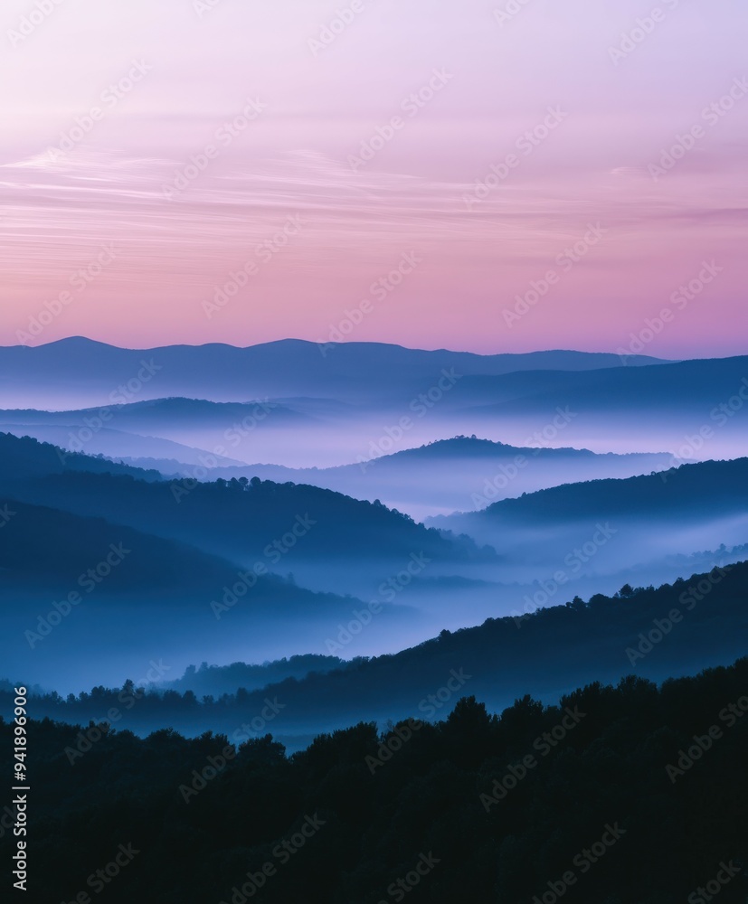 Obraz premium Dawn breaks over misty blue mountains in serene early morning light