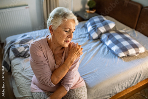 Senior woman holding shoulder in pain at home photo