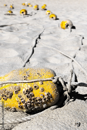 Yellow float barrier on beach sand photo