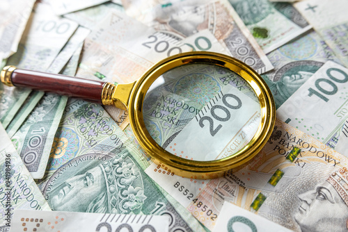  Polish zloty bills and magnifying glass financial investment concept