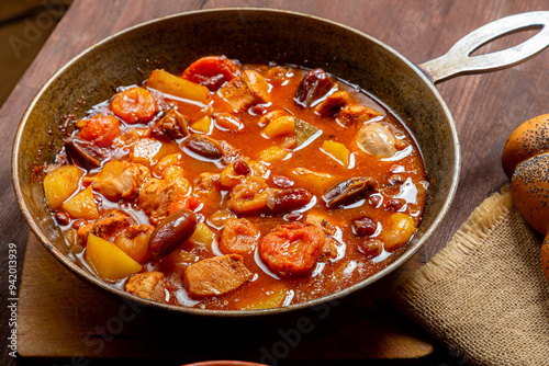 Hot cholent in a cast iron pan on the festive table for the Rosh Hashanah meal photo