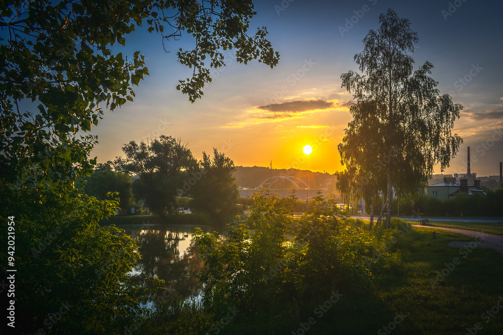 Wschód słońca nad rzeką w otoczeniu drzew