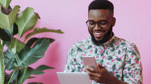 Afro-American man shopping online using phone and tablet, enjoying digital shopping experience