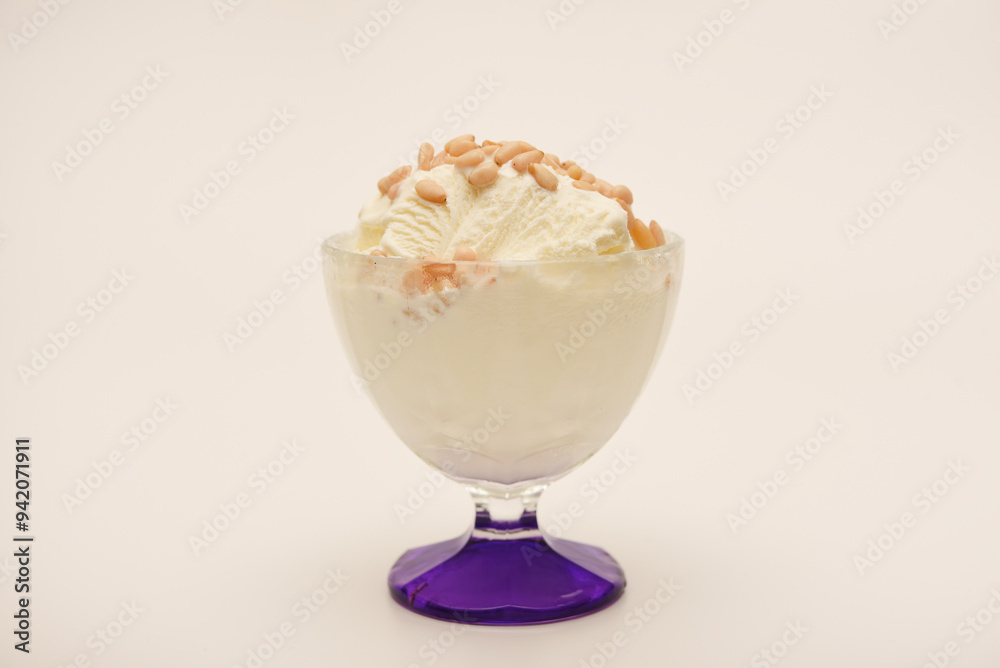 Ice cream in a glass ice cream maker with pine nuts. Ice cream with nuts. Ice cream in a glass ice cream maker with pine nuts. Ice cream with nuts.