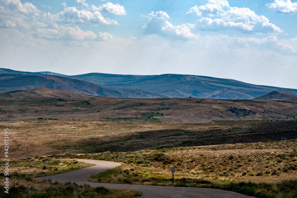 A road in Fossil Butte National Monument leads into Fossil Butte Valley, winding past Dynamic Lake in Wyoming's unique landscape and geological features. A road in Fossil Butte National Monument leads into Fossil Butte Valley, winding past Dynamic Lake in Wyoming's unique landscape and geological features.