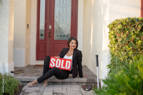 realtor woman with a sold sign photo