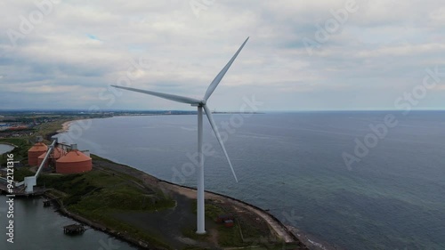 Drone video of a large wind  turbine on the river bank