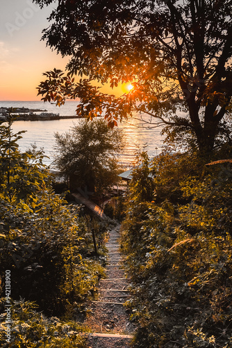 Stairs leading down to the sea. Warm and cozy autumn sunset on the high seashore. Feelings of calm, happiness, measuredness. photo