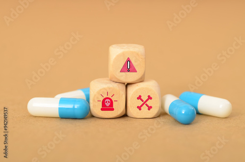 Принти на полотні wooden block with symbols of an exclamation point, a siren, a skull and crossbones, and capsules visually represents the potential dangers and consequences associated with medication misuse